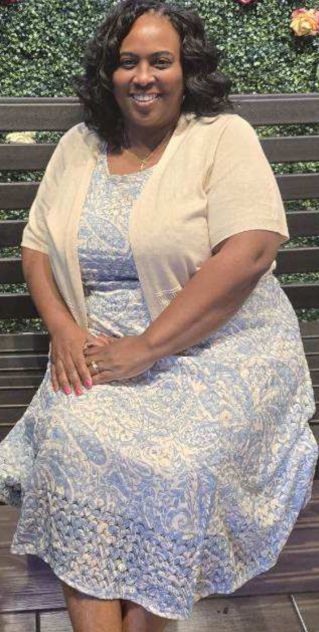 Stylish woman in orange outfit enjoying ice cream at a charming outdoor cafe, exuding summer vibes.
